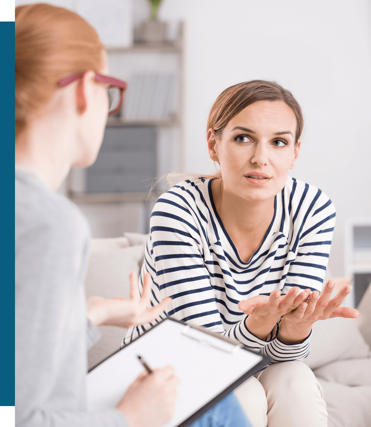 Two women engaged in a thoughtful conversation in an office setting.