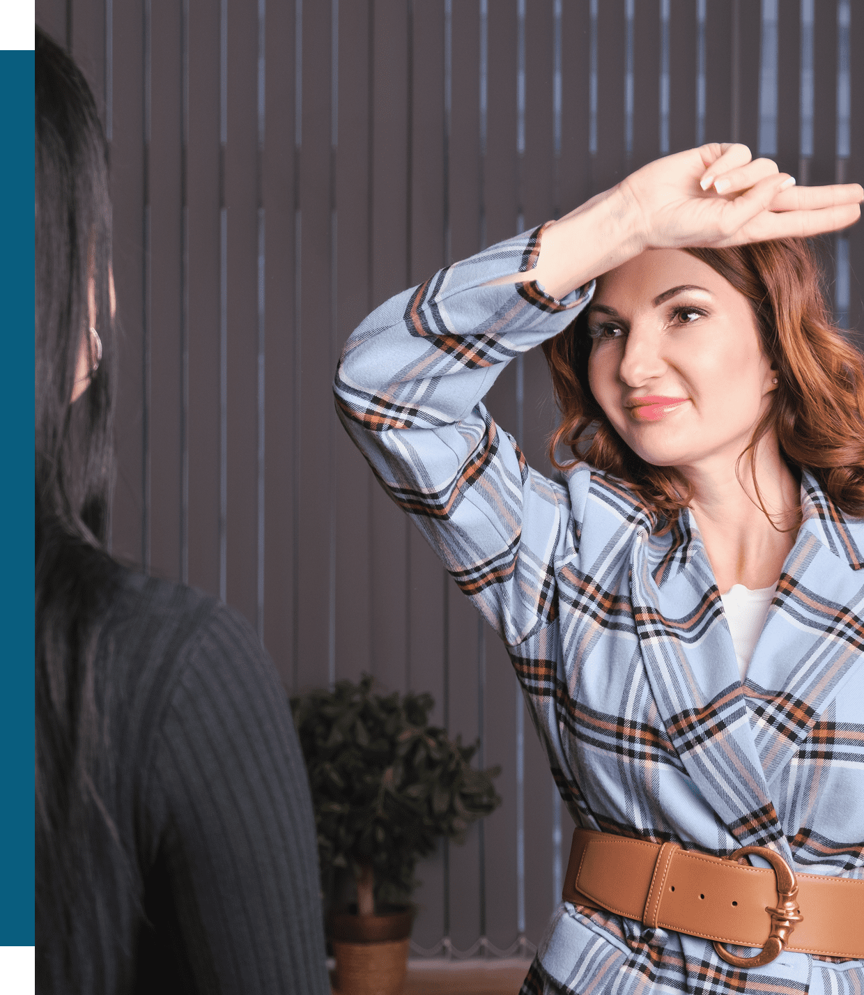 Woman shielding eyes from bright light indoors.