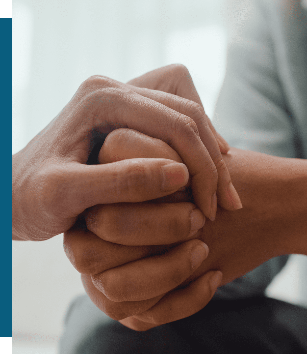 Two people holding hands in a comforting gesture.